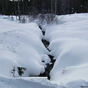 stromende beek onder de sneeuw
